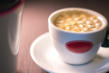 Coffee in cafe with marshmallow with blurred background.