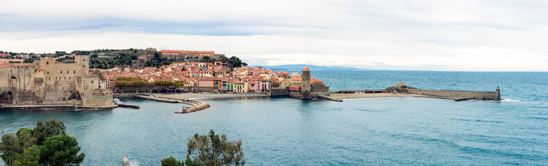 Fototapeta na wymiar Panoramic view to picturesque old house facades, Collioure castle, bell tower of Notre Dame des Anges church and lighthouse