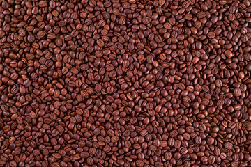 Roasted coffee beans on a flat background.