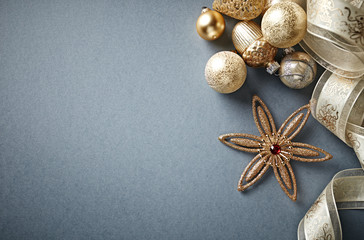 Fototapeta na wymiar Golden Christmas Ornaments with Satin Ribbon on Gray Background