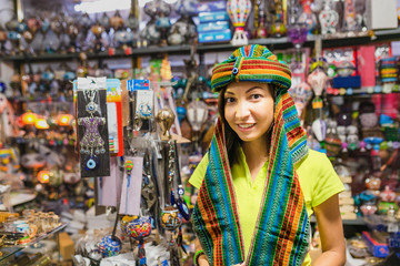 Woman shopping and trying a traditional arabic or middle east head wear turban in souvenir market in Turkey