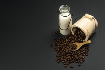 A cup of coffee and coffee bean grain on sack fabric put on black wood table background include copyspace for add text or graphic