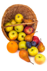 apples and other fruits in a wicker basket on a white background.