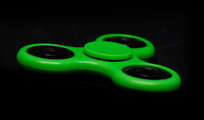 Green fidget spinner on a black background