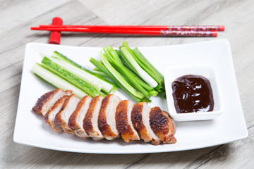 Baked duck with hoisin sauce, cucumbers and shallots. Selective focus, close-up.