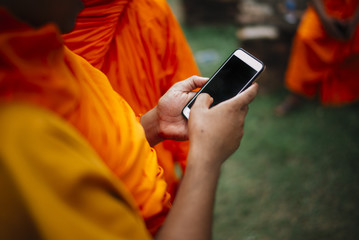 Buddhist monk holding the Smartphone with your hands