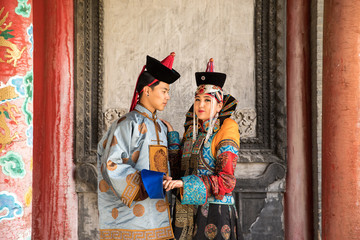 Fototapeta na wymiar Young Mongolian couple in a traditional 13th century costume in a temple. Ulaanbaatar, Mongolia.