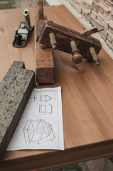 Carpentry concept. Joiner carpenter workplace. Old jack-plane, jointer , drawing and piece of wooden board on a wooden table