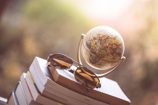Globus, Stapel B&uuml;cher und Sonnenbrille, drau&szlig;en, Weltreise