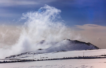 Paesaggio con Cratere innevato sul Vulcano etna in Sicilia durante stagione invernale e nuvole