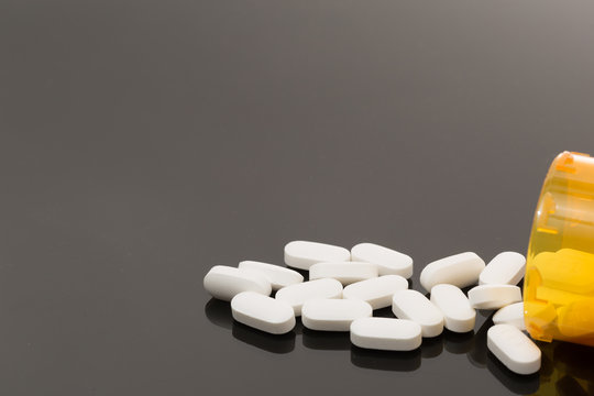 opioid white pills spilled out on table for health addiction pain medicine