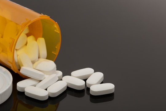 opioid white pills spilled out on table for health addiction pain medicine