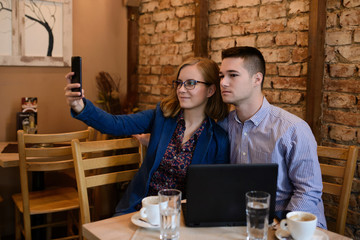Happy couple in a coffee shop using digital tablet and mobil phone