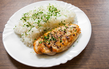 fried chicken breast with rice on a wooden background.