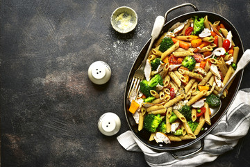 Whole grain penne pasta with vegetable and roasted chicken.Top view.