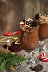 Festive hot chocolate with whipped cream and cookies.