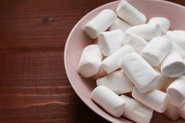 marshmallow in a pink plate on a wooden table