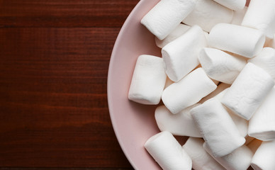 marshmallow in a pink plate on a wooden table