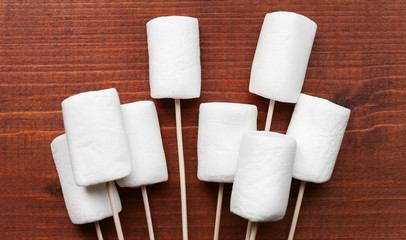 marshmallows put on a wooden stick and lying on a table