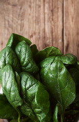 wet spinach leaves on a wooden background