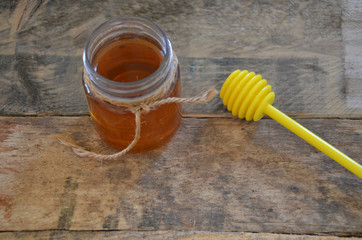 Honey bottle. a stick for honey. on a wooden background