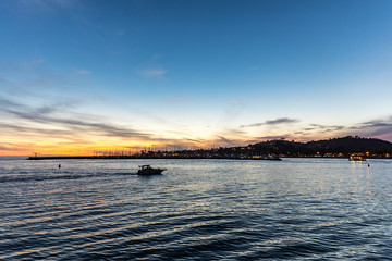 boat going back to the harbor at sunset time when the sky is very beautiful and colorful