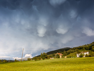 Fototapeta na wymiar Threatening stormy clouds over small houses, Belluno, Italy
