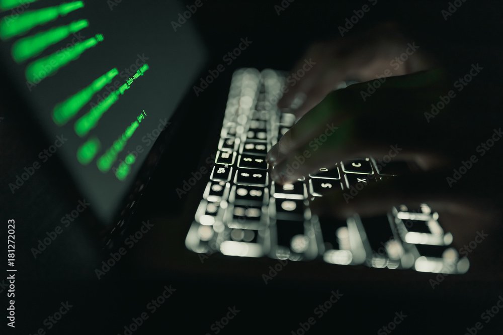 Wall mural Cyber crime concept: hands of a person hacking on laptop in the darkness