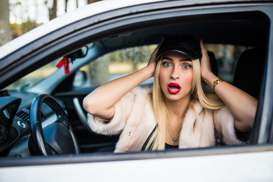 Distracted Fright Face Of A Woman Driving Car, Wide Open Mouth Eyes Holding Wheel Side Window View. Negative Human Face Expression Emotion Reaction.