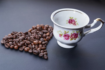 Obraz na płótnie Canvas Coffee beans in heart shape with coffee cup