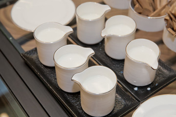 Top view of glass milk jug with milk on the white in the hotel