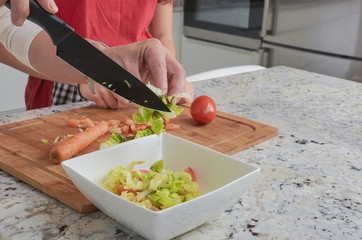 Mother and her teenage daughter are cooking together in the kitchen, prepare a salad. Vegan Family.