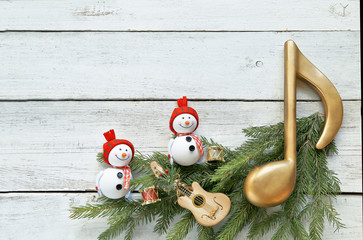 Snowman with christmas tree , music notes, instruments on wooden background 
