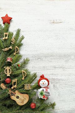 Snowman with christmas tree , music notes, instruments on wooden background 