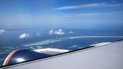 Aerial View from seaplane window over Atolls at Indian Ocean Maldives