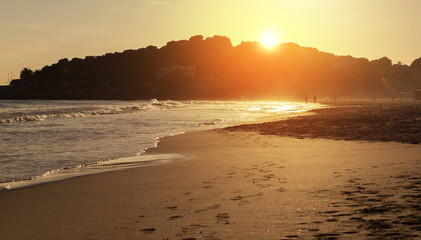Fototapeta na wymiar walking on the beach at sunset