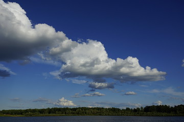 a series of white cumulus clouds above the ground