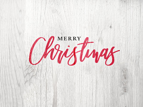 Festive Merry Christmas Calligraphy Text Over White Rustic Wood Background
