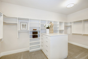 Fototapeta na wymiar Huge walk-in closet with shelves, drawers and clothes rails