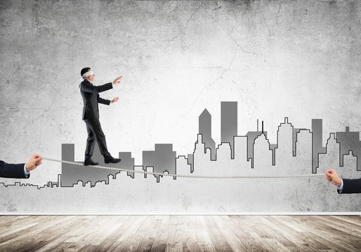 Business concept of risk support and assistance with man balancing on rope
