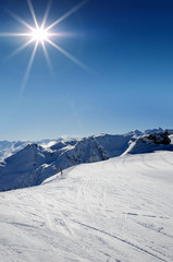 Skipiste mit Bergkette im Gegenlicht Montafon Vorarlberg