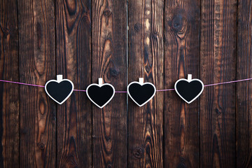 little four hearts on a rope with the hang on a rope on a wooden brown background