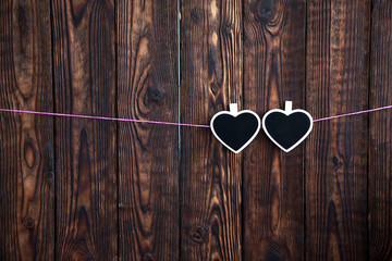 little two hearts on a rope with the hang on a rope on a wooden brown background