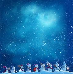 Fototapeta na wymiar Merry Christmas and happy New Year greeting card with copy-space.Many snowmen standing in winter Christmas landscape.Winter background