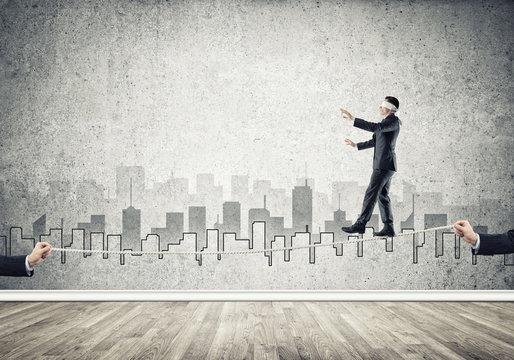 Business concept of risk support and assistance with man balancing on rope