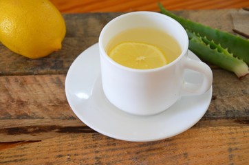Drink with aloe vera and lemons. Glass cups on wooden background