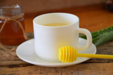 Hot drink with honey, lemon and aloe vera for cough remedy on wooden table