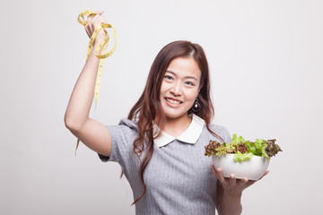 Healthy  Asian woman with measuring tape and salad.