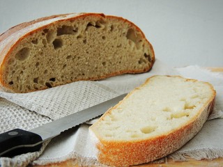 Fresh loaf of bread on linen towel.