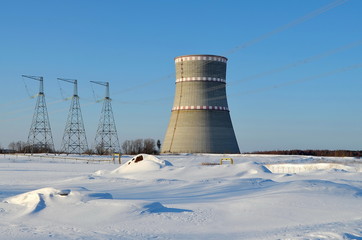 Obraz premium cooling tower on a background of blue clear sky and white snow, landscape